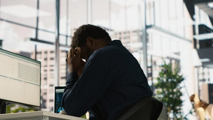 Worker feeling painful headache while working, suffering burnout